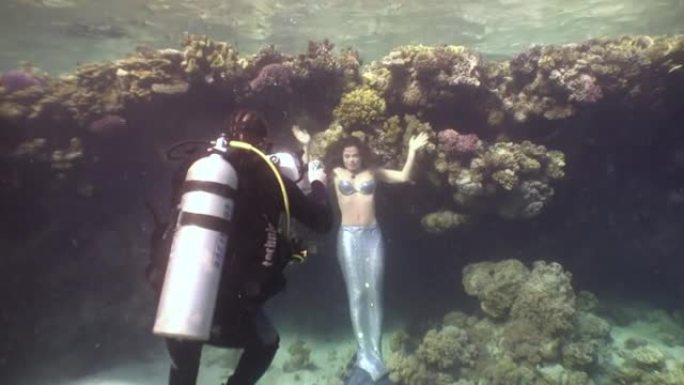 摄影师拍摄视频年轻女子水下模型美人鱼。