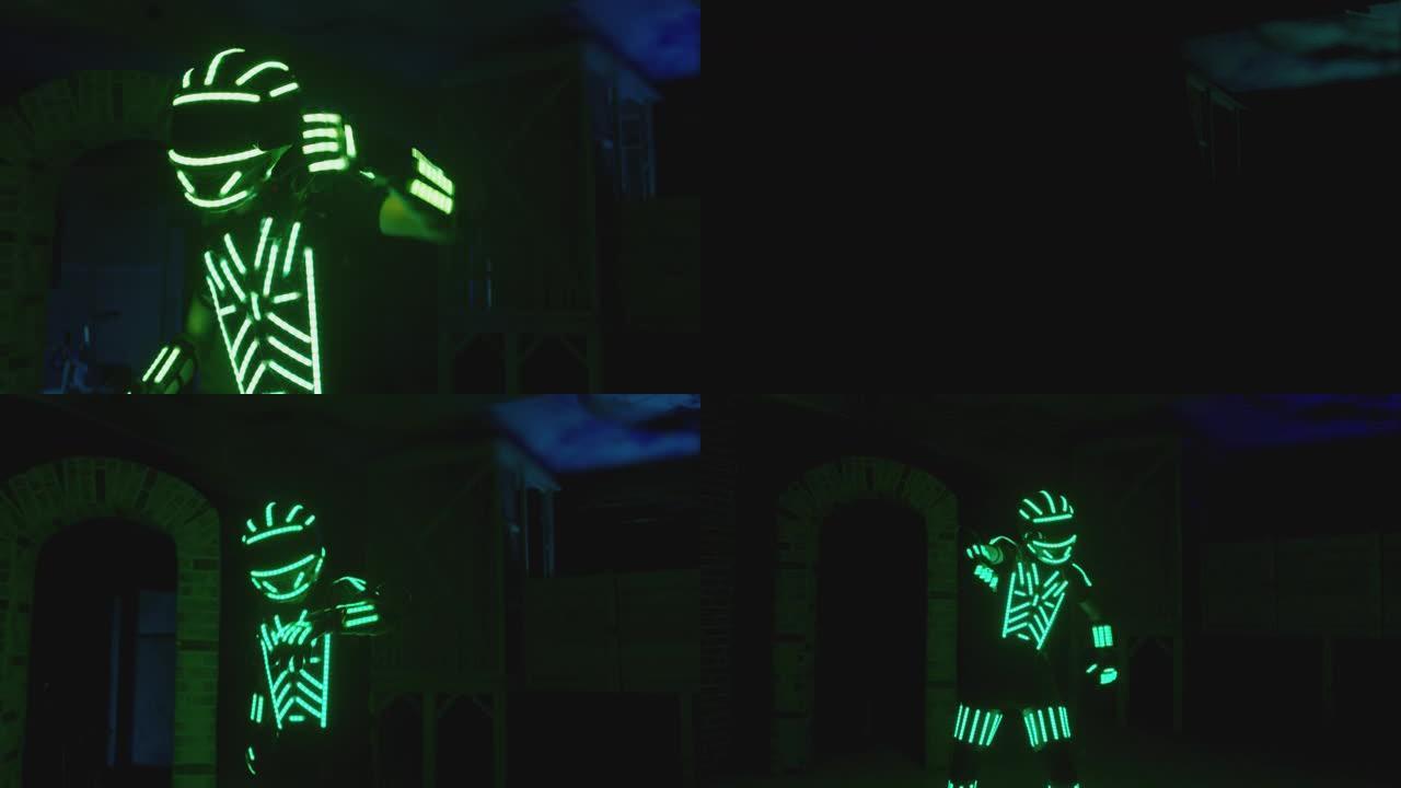 4k男子穿着照明服装，五颜六色的灯光在黑暗的室内或俱乐部里跳舞和移动。舞者穿着身上带有霓虹灯或led