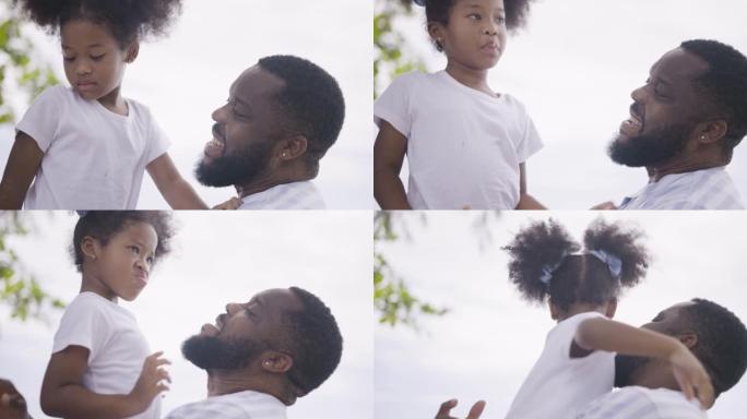 微笑的非洲男子与她可爱的小女儿玩耍的镜头