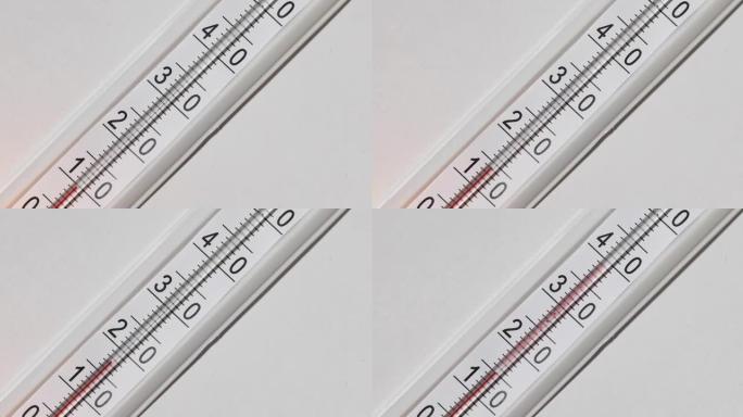 白色背景上的温度计。温度计上的温度升高，就会分解。红色液体是甲基卡必多醇。