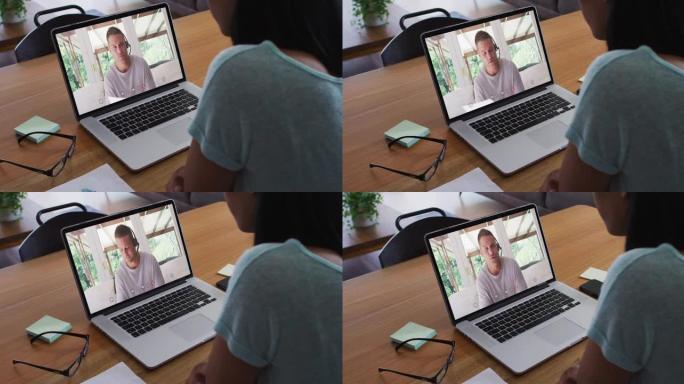 非裔美国妇女在家里的笔记本电脑上与男性办公室同事进行视频通话