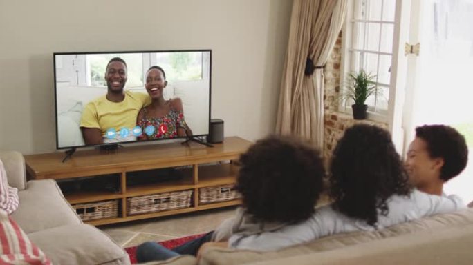 非裔美国人家庭坐在家里的沙发上在电视上播放视频通话