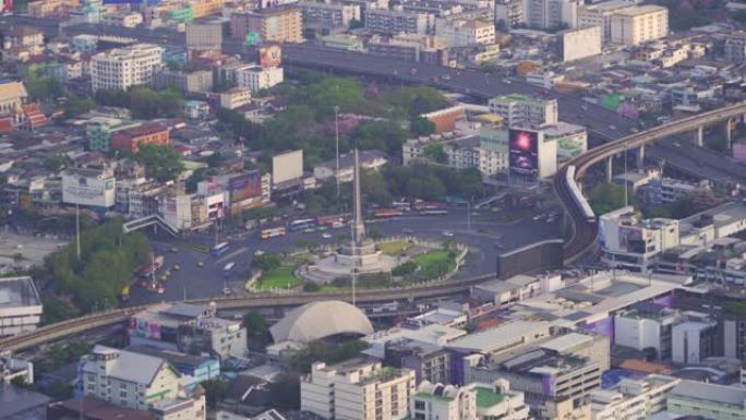 繁忙街道路上胜利纪念碑的鸟瞰图。曼谷市中心天际线的环形交叉路口。泰国。智慧城市金融区中心。日落时的摩
