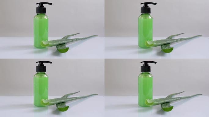绿色奶油罐，带有灰色背景的芦荟叶分配器的凝胶，护肤化妆品。