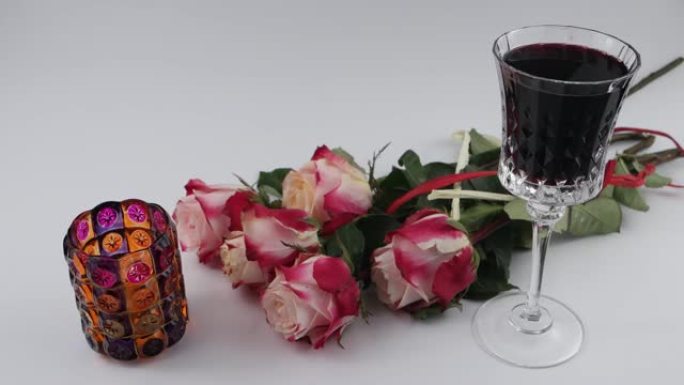红酒，燃烧的蜡烛和华丽的玫瑰花酒杯