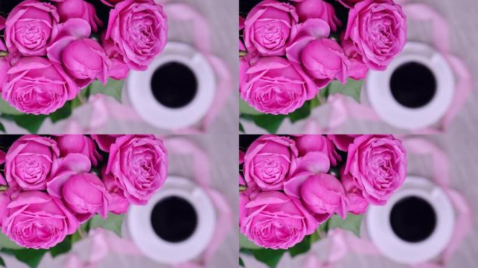 一杯咖啡和粉红玫瑰。假日概念，生日的玫瑰花花束，早餐的花束。女人喝卡布奇诺