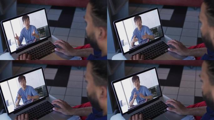 中东男子在笔记本电脑上与男性办公室同事进行视频通话