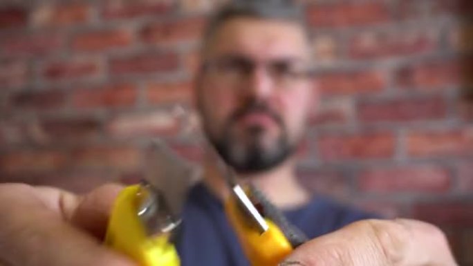 男性手中的黄色文具刀