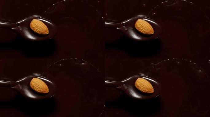 融化的液体优质黑巧克力和杏仁旋转，用坚果制作甜甜点的过程