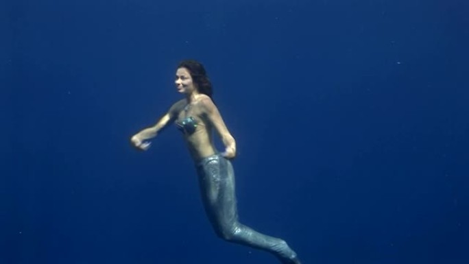 红海蓝色背景下的年轻女孩模特水下海员服装。
