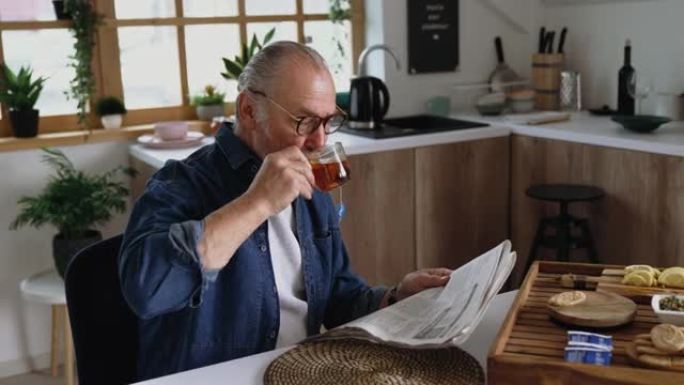 早上喝茶时看报纸的老人