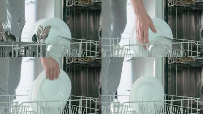 女子打开洗碗机门，拉出底部漆成白色的抽屉，轮流拿出餐具托盘、清碗、白汤碗。特写