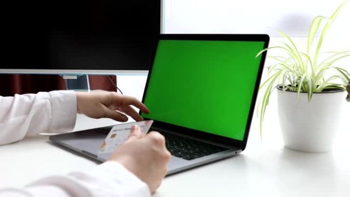 带绿屏手提银行卡的笔记本电脑