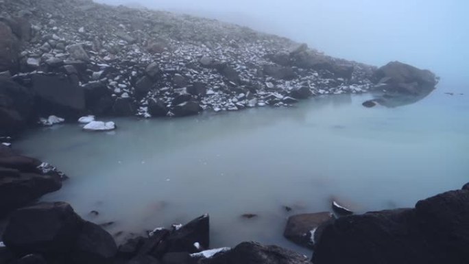 高山湖泊，有岩石海岸和翡翠水。早晨霜冻。