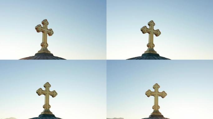 早晨日出时，金色十字架在湛蓝的天空下的轮廓。东正教基督耶稣受难像被阳光照亮。对黄金构成的上帝信仰的宗