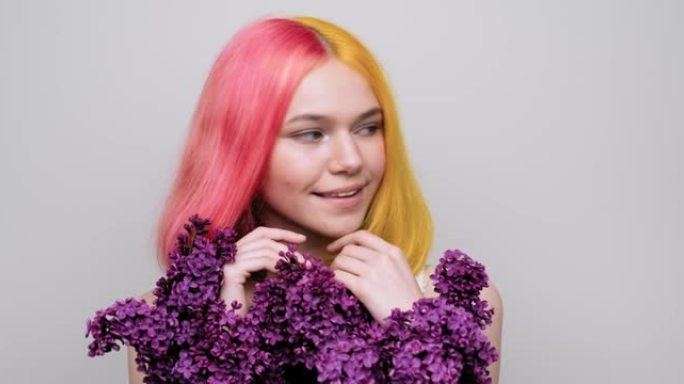 染成紫色黄色头发的少女手里拿着丁香花
