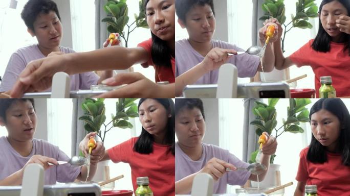 快乐的亚洲儿童，您可以通过智能手机制作视频，在家中一起烹饪一些甜蜜的零食，生活方式概念。
