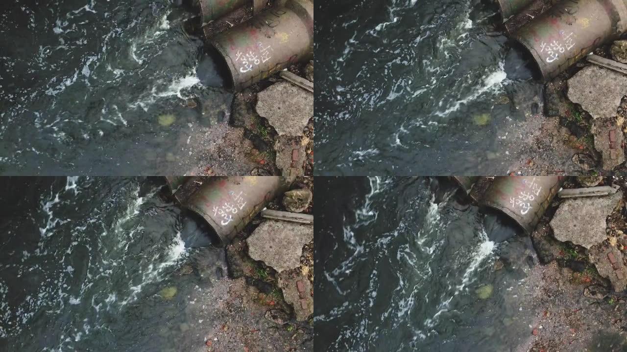 水流通过混凝土下水道。公园里被污染的水体。用无人机拍摄通过关闭摄像机。
