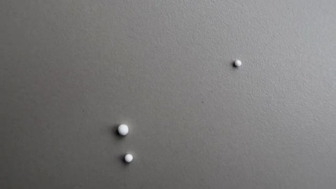 白色聚苯乙烯球在瓷砖地板上滚动并从视野中消失
