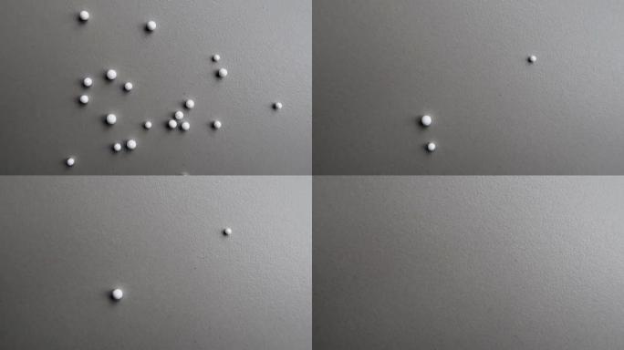白色聚苯乙烯球在瓷砖地板上滚动并从视野中消失