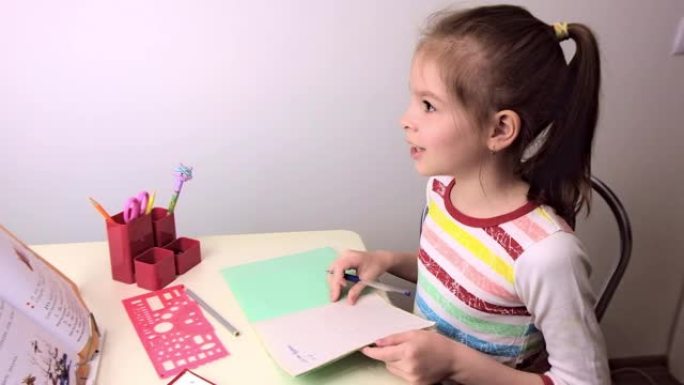 女学生，黑发小女孩在客厅的桌子上上课。桌子上放着笔记本、课本、钢笔、学习用品。俄罗斯