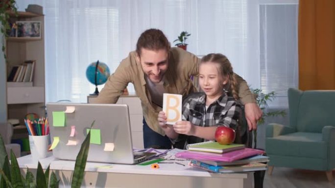远程教育，慈爱的父亲帮助他的女儿在家里检疫期间通过视频链接与老师在线学习课程