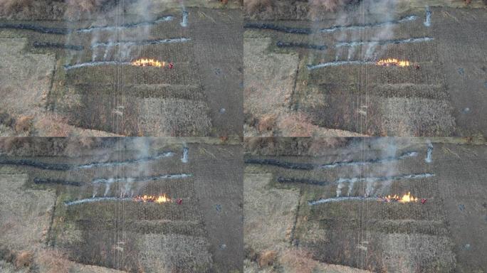 一名乡村居民在田野，乡村场景中放火烧干草的无人机镜头