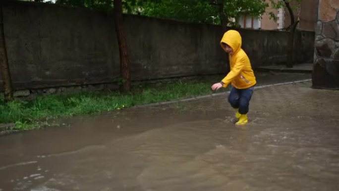 可爱的小男孩在雨天玩耍