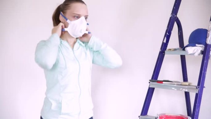 一名年轻女子戴上呼吸器，拿起刷子进行维修工作。