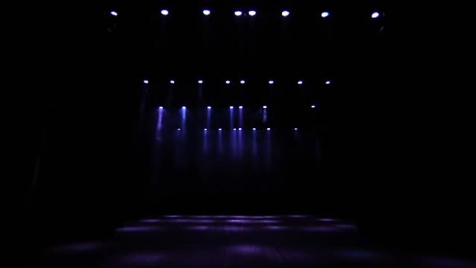 音乐厅空荡荡的舞台上有许多照明装置。