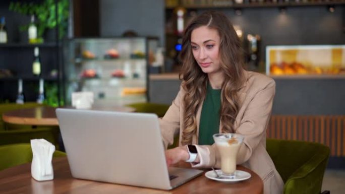 商务女性餐厅老板在酒吧柜台背景的餐厅使用笔记本电脑穿着优雅的长裤套装坐桌