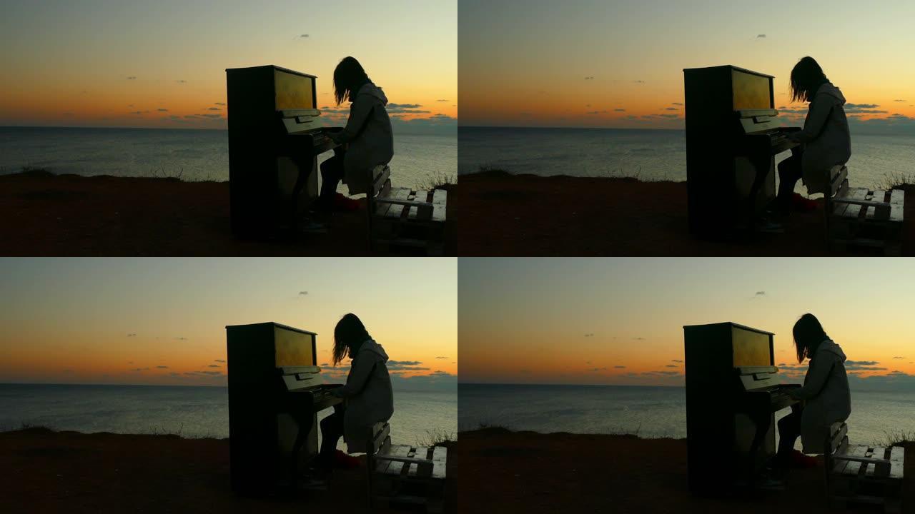 日落时在海滩上弹钢琴的女孩的剪影
