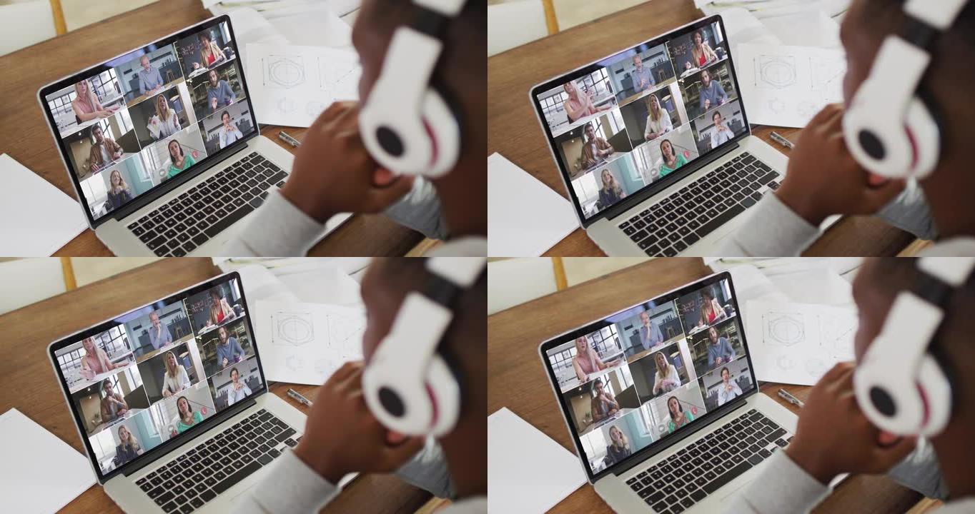 非裔美国男大学生戴着耳机在家里的笔记本电脑上进行视频会议
