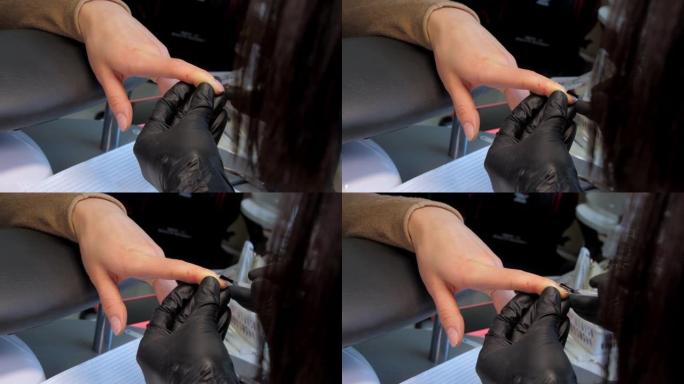 无菌手套美容师在指甲上涂抹基础凝胶