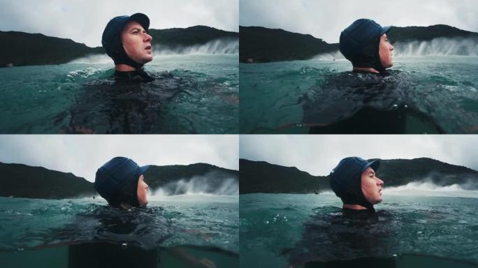 冲浪摄影师。戴着防护帽的男人环顾四周，在汹涌的大海中