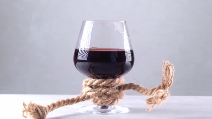 酒杯用绳子绑着。酒精依赖的概念