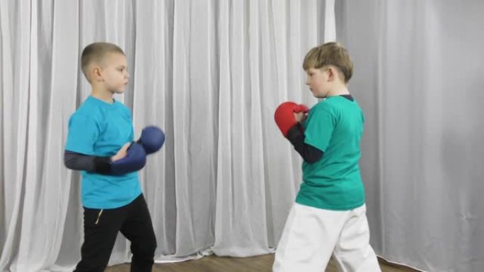 两名身穿彩色t恤和护垫的运动员在他们的手臂上训练积木和拳打以相遇