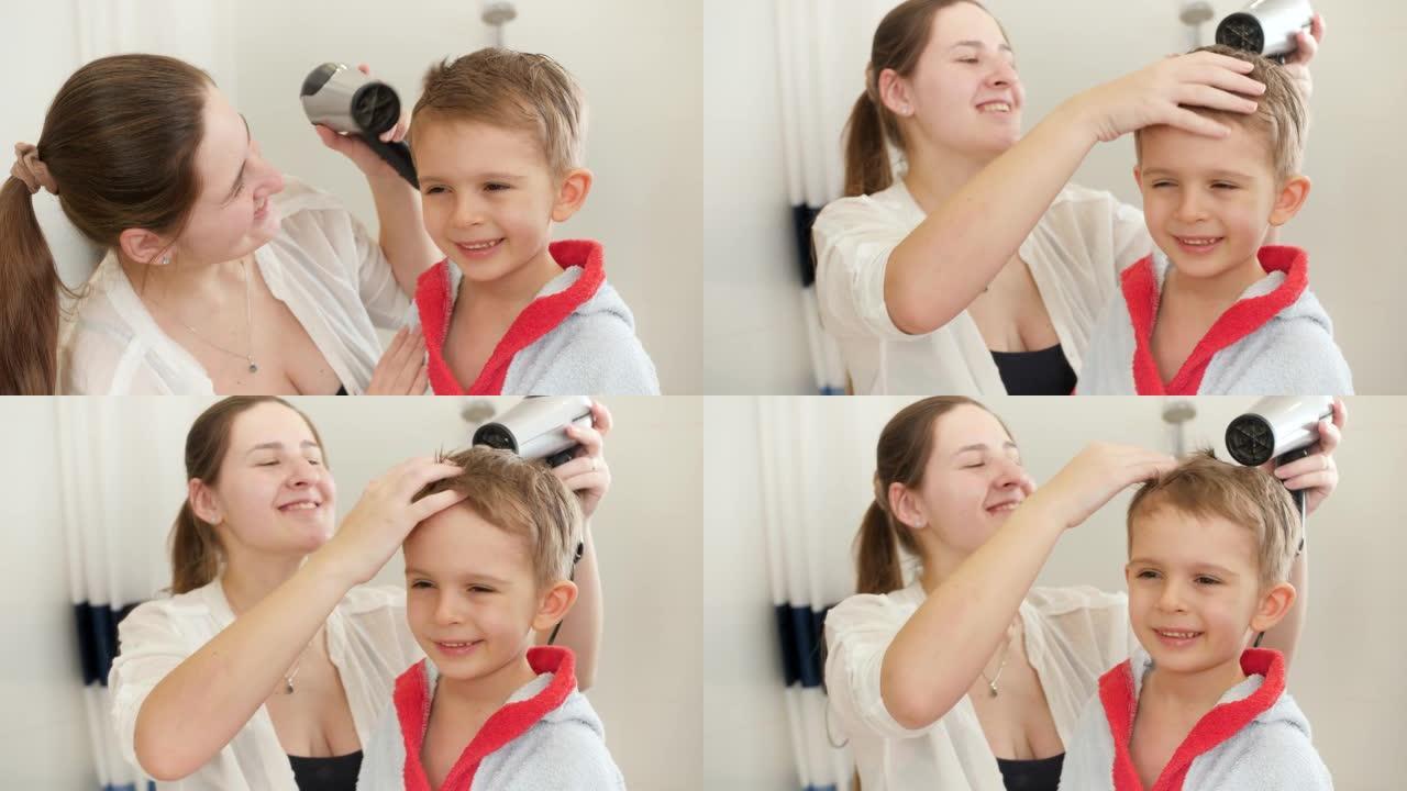 穿着浴袍的可爱的小男孩照镜子，母亲在浴室用吹风机吹干头发。儿童卫生和家庭保健的概念。家里有爱心的父母