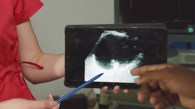 现代诊所的年轻女性白人医生，拿着平板电脑，用超声波扫描演示数字平板电脑，在泌尿外科医疗中心现代超声波