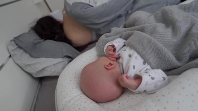 可爱的男婴躺在婴儿荚巢新生儿茧，婴儿睡眠安全，与婴儿共睡床。