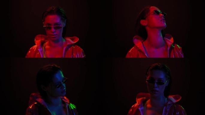 艺术设计慢动作女孩在黑色背景上的霓虹灯中移动。美丽的女孩戴着墨镜在灯光下跳舞。夜总会，派对。FHD镜