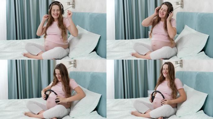 快乐微笑的孕妇戴着耳机享受音乐和跳舞。未出生的婴儿在母亲腹部听经典音乐。早期艺术与创造力发展的概念