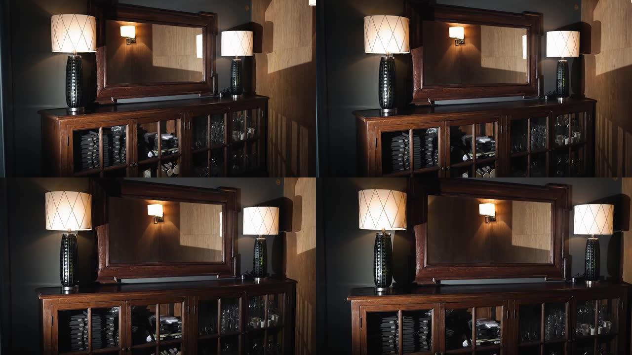 一面非常漂亮的仿古木镜，侧面有两盏灯。昂贵的家具装饰着房间。摄像机平稳移动