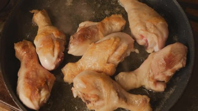 鸡腿用植物油在大煎锅中油炸。煎锅里烤禽肉的俯视图。脂肪油炸食品会导致心脏病