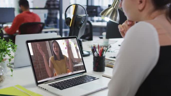 白人妇女在办公室的笔记本电脑上与女同事进行视频通话