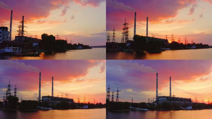 河边制造业。日落时分，自然界中的工业厂房和高压电塔。从河边看。鸟瞰图。