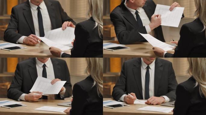 合作伙伴讨论合同。女人看文件并签名。男子在办公室会议上与缔结合同的妇女握手。特写。慢动作就绪，4k，