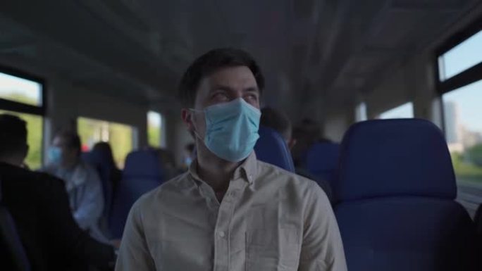 在火车内新型冠状病毒肺炎锁定期间戴着口罩的男性乘客。新的正常生活方式概念。乘坐公共交通工具旅行时的社