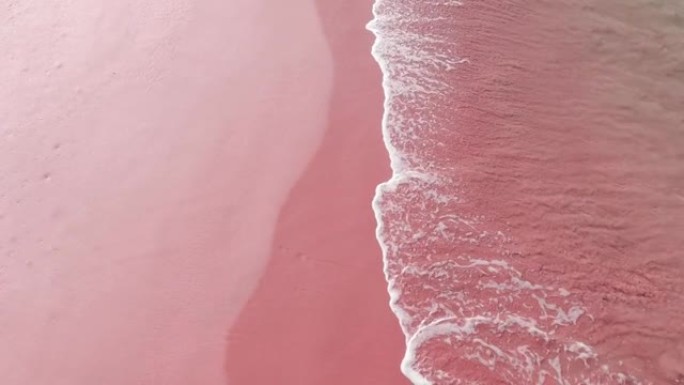 平静的海浪蓝色海水撞击粉色沙滩