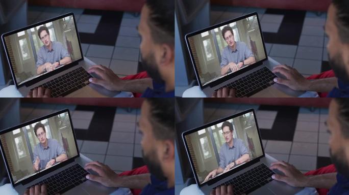 中东男子在笔记本电脑上与男同事进行视频通话